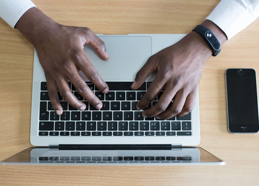 Man writing on laptop keyboard